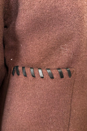 Close up of brown wool coat’t pocket with whipstitch detailing