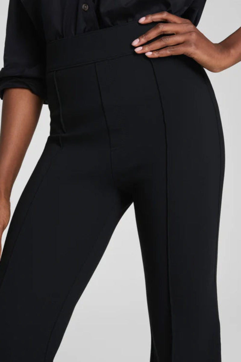 Person wearing black pants on a plain background
