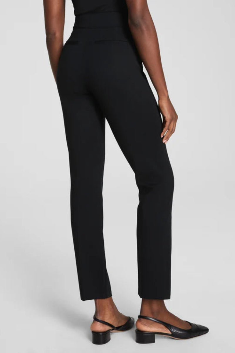Person wearing black pants on a light gray background