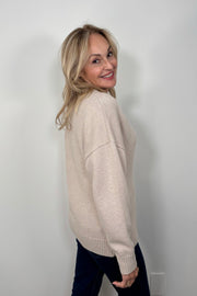 side view of a woman wearing a fitted 3 button beige knitted cardigan