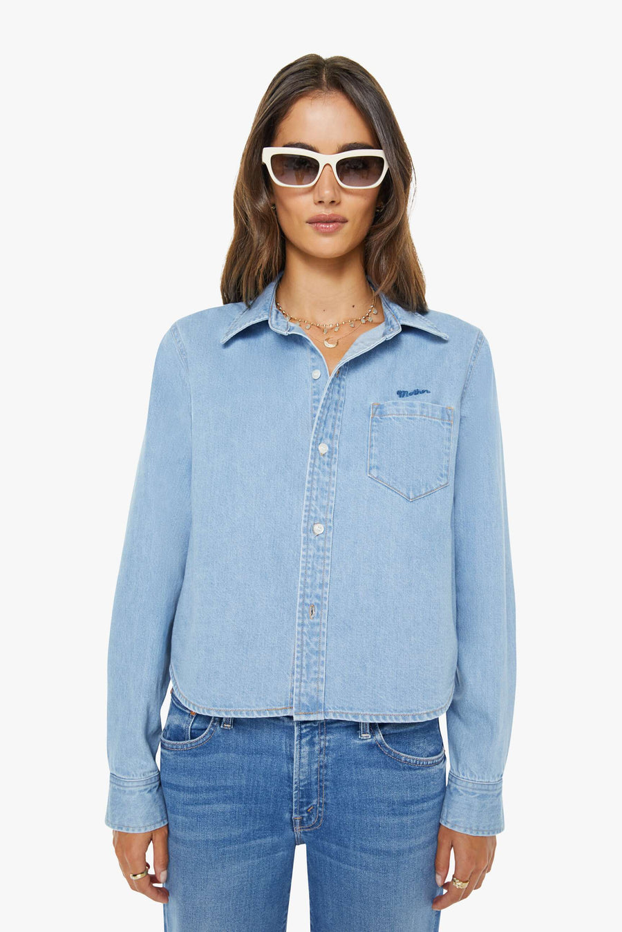 a woman wearing a light wash denim collared button up with side pocket