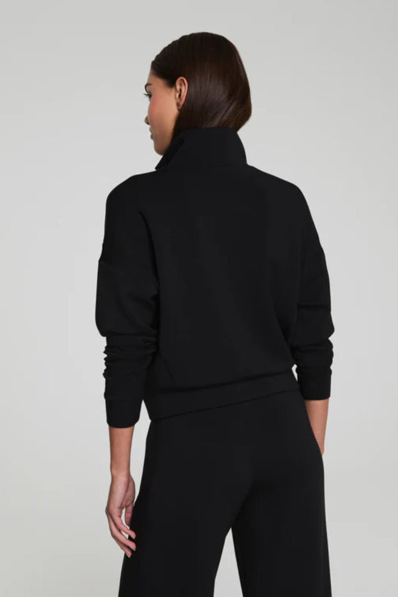 Person wearing a black track jacket from the back