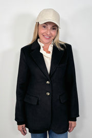 front view of woman wearing a blazer with cuffed sleeves