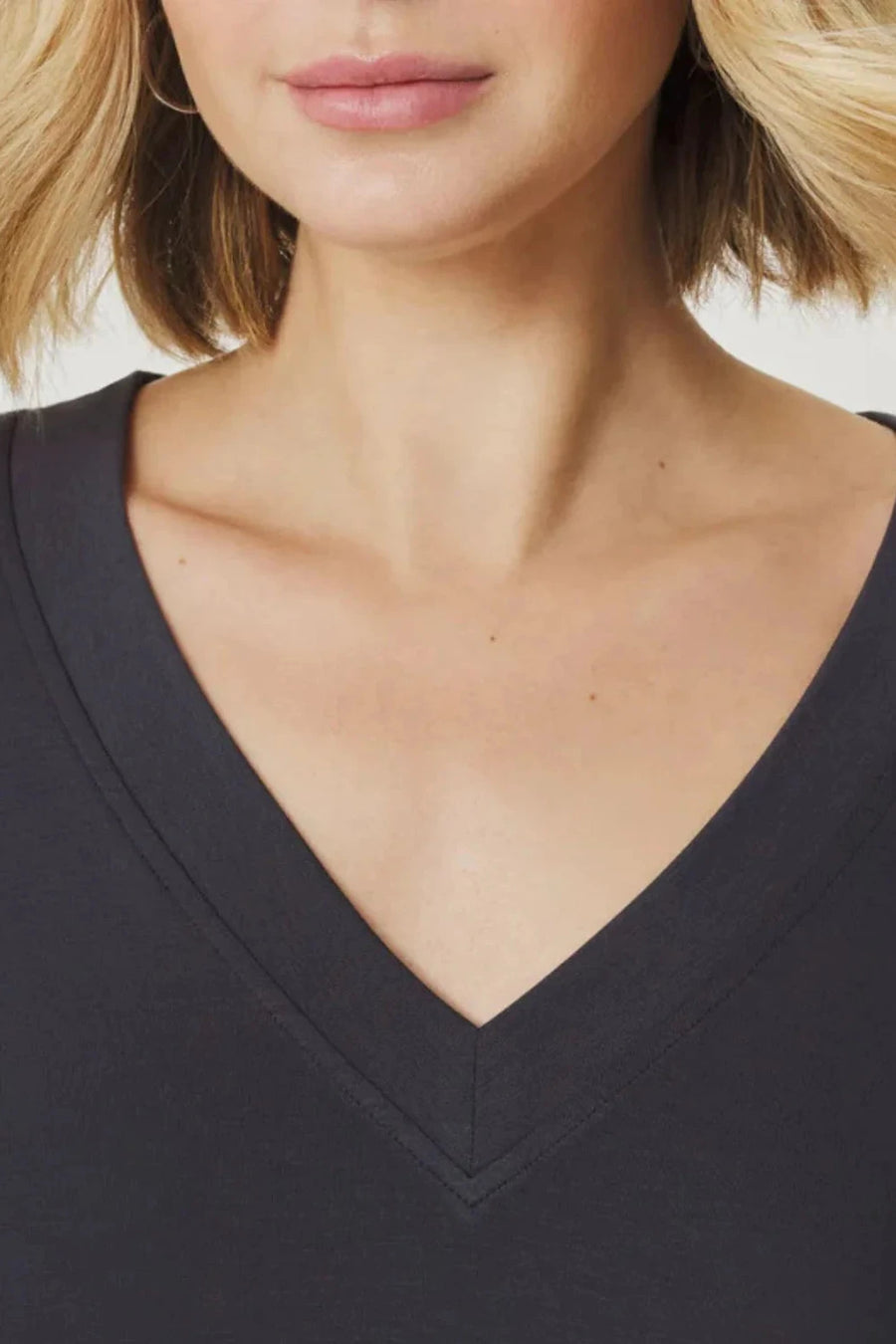 Woman wearing a v neck tee shirt in dark grey Close up