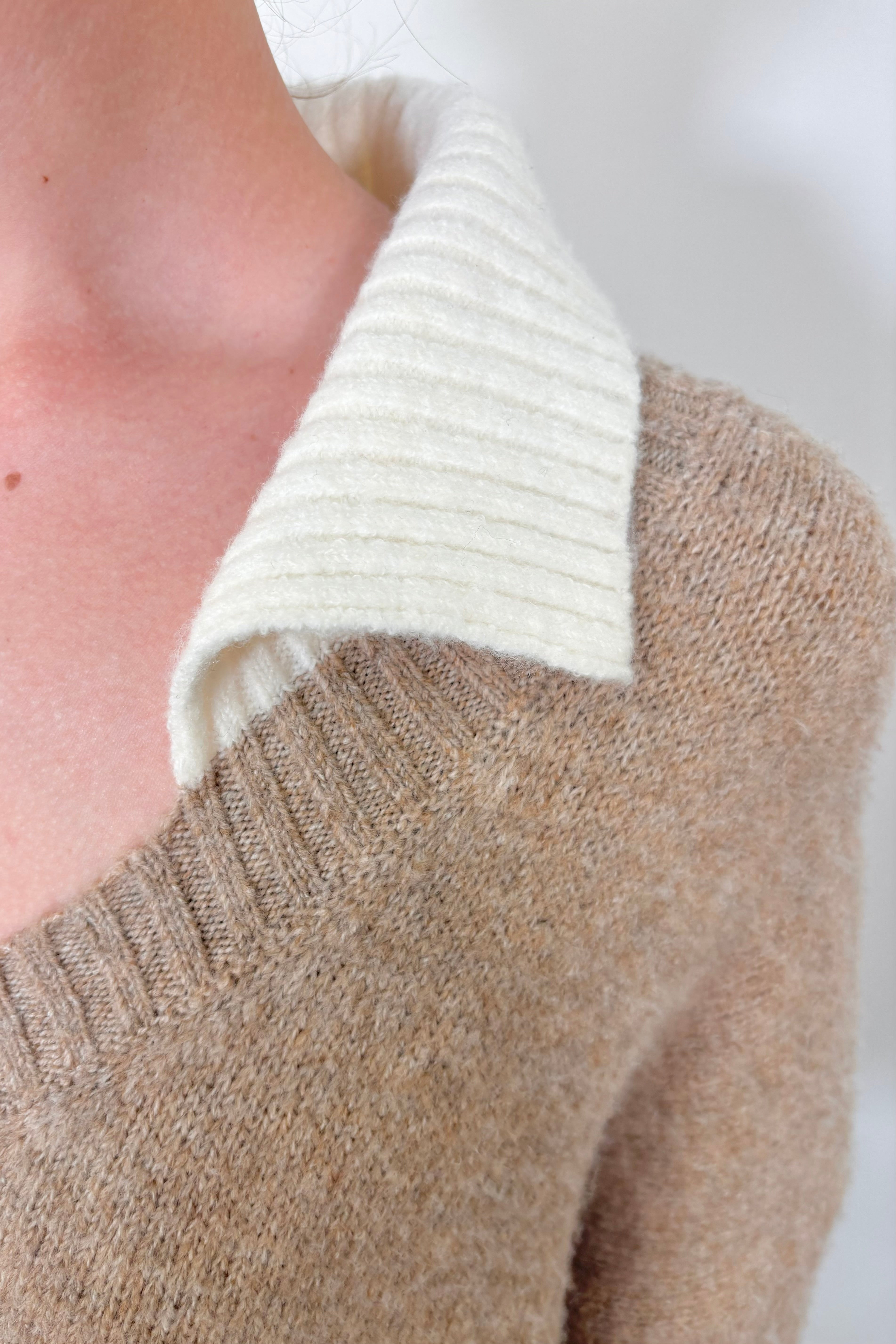 close up of the collar of a beige sweater