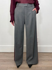 Front view of woman wearing a gray pinstripe wide leg pant with a burgundy line down the leg