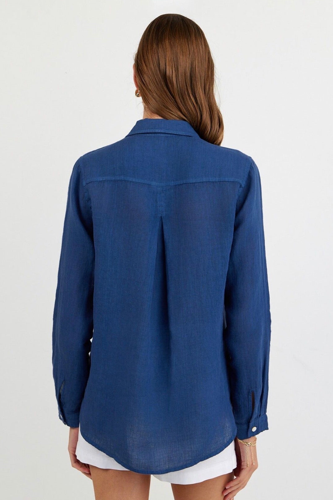 Back view of Woman wearing a dark blue linen button up with pocket on side chest