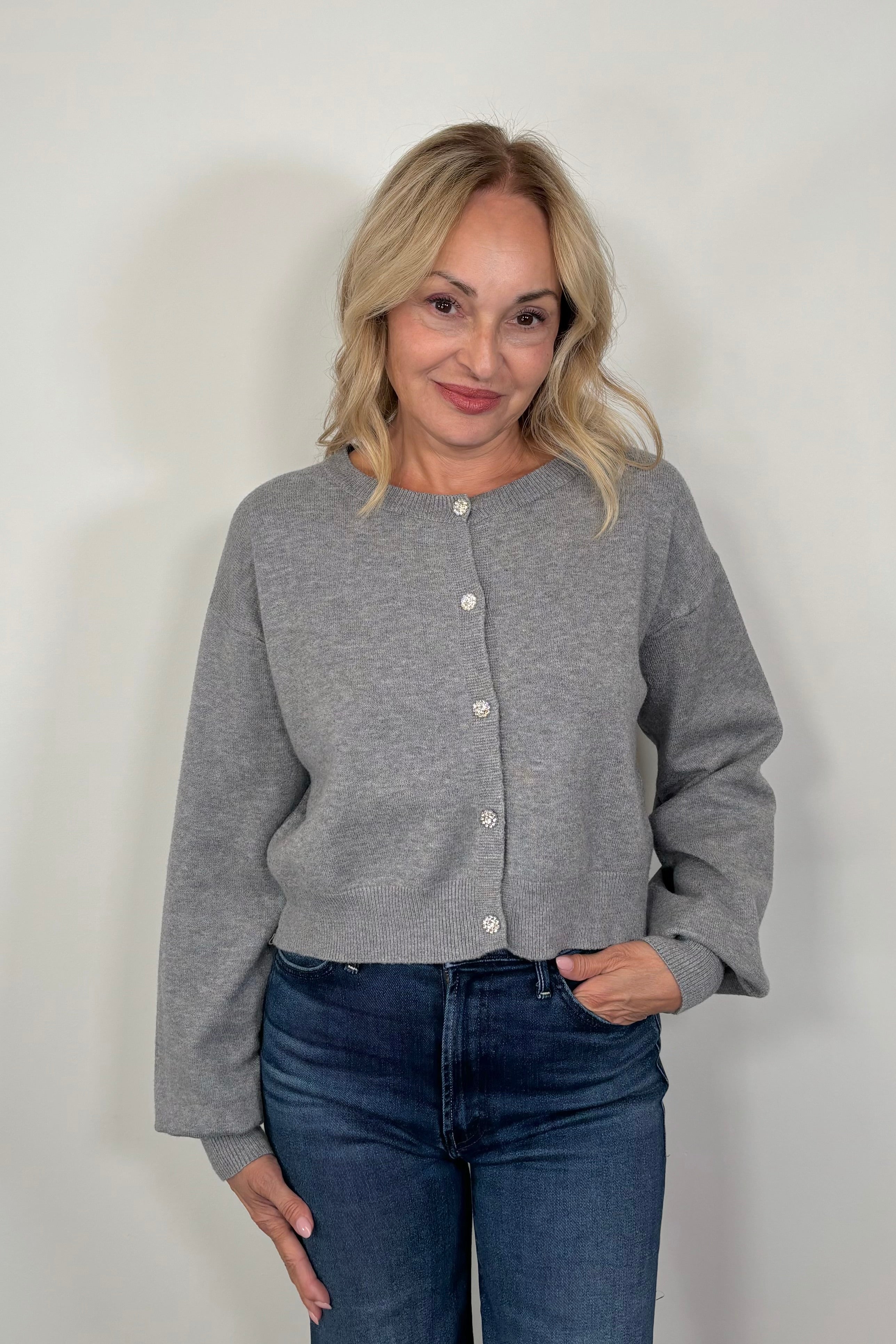 woman wearing gray cardigan with crystal buttons