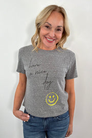 Woman wearing a gray t-shirt with 'Have a nice day' text and smiley face design