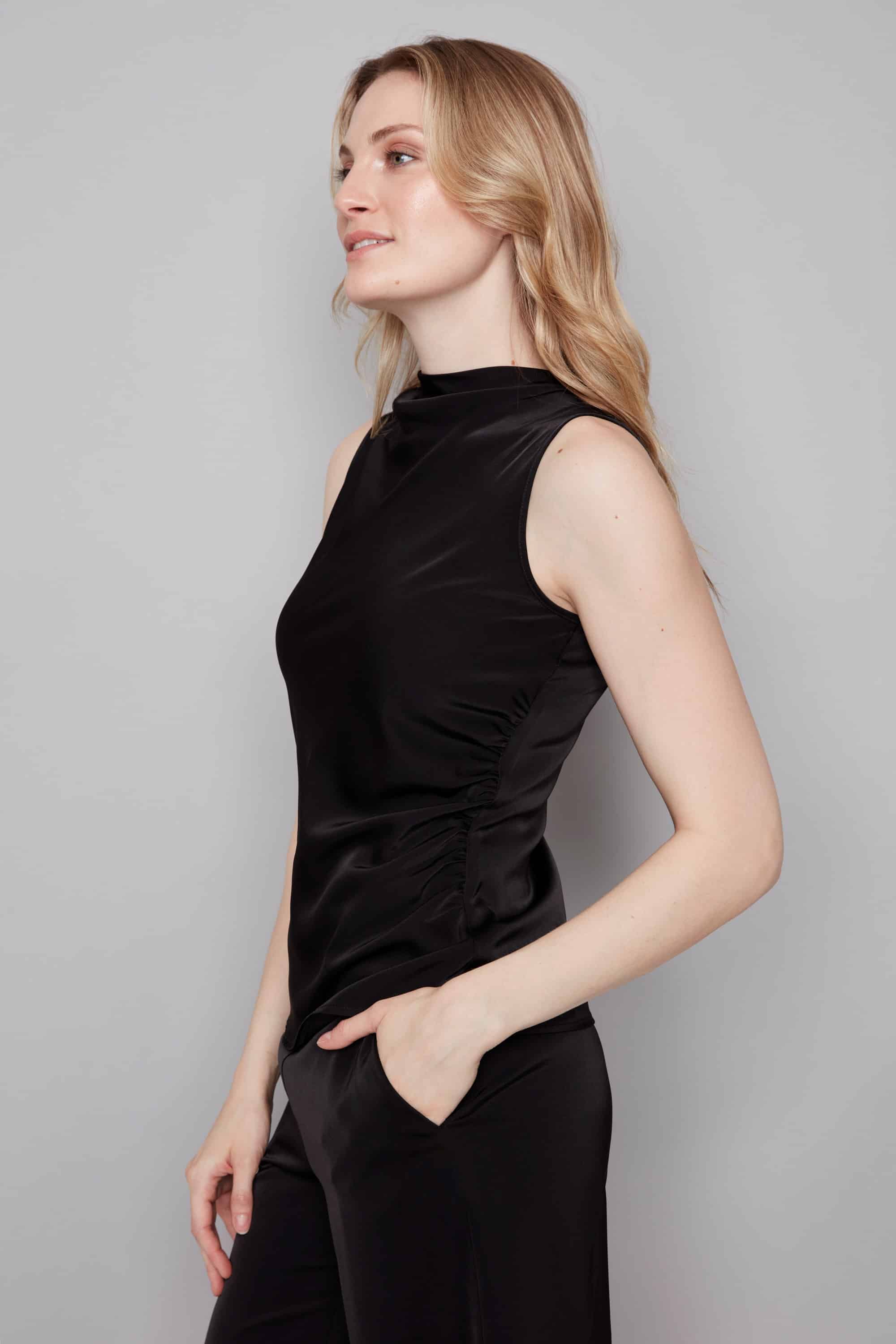 Woman wearing a black sleeveless top against a gray background