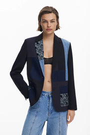 Front view of a woman wearing a multi texture blazer with jeans