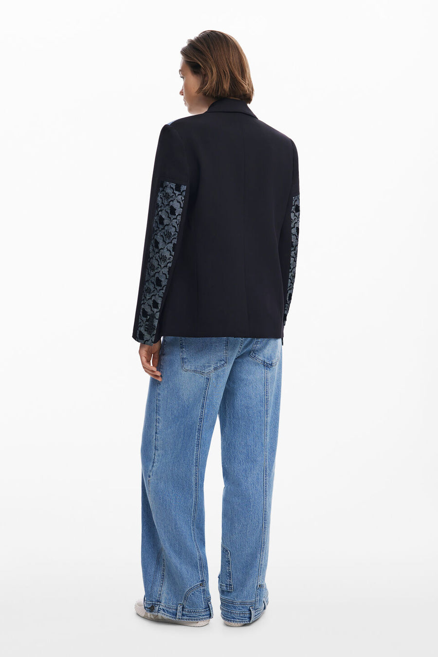 Back full body view of a woman wearing a multi texture blazer