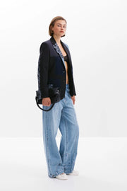 Side view of a woman wearing a multi texture blazer