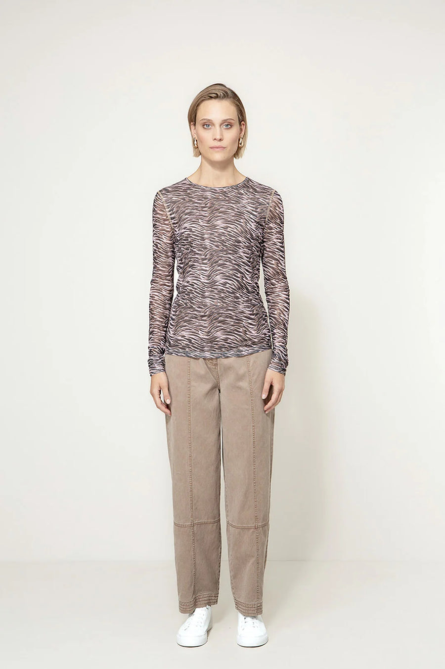 woman wearing long sleeve top with black patterning 