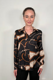Front view of a woman wearing a printed button up shirt untucked