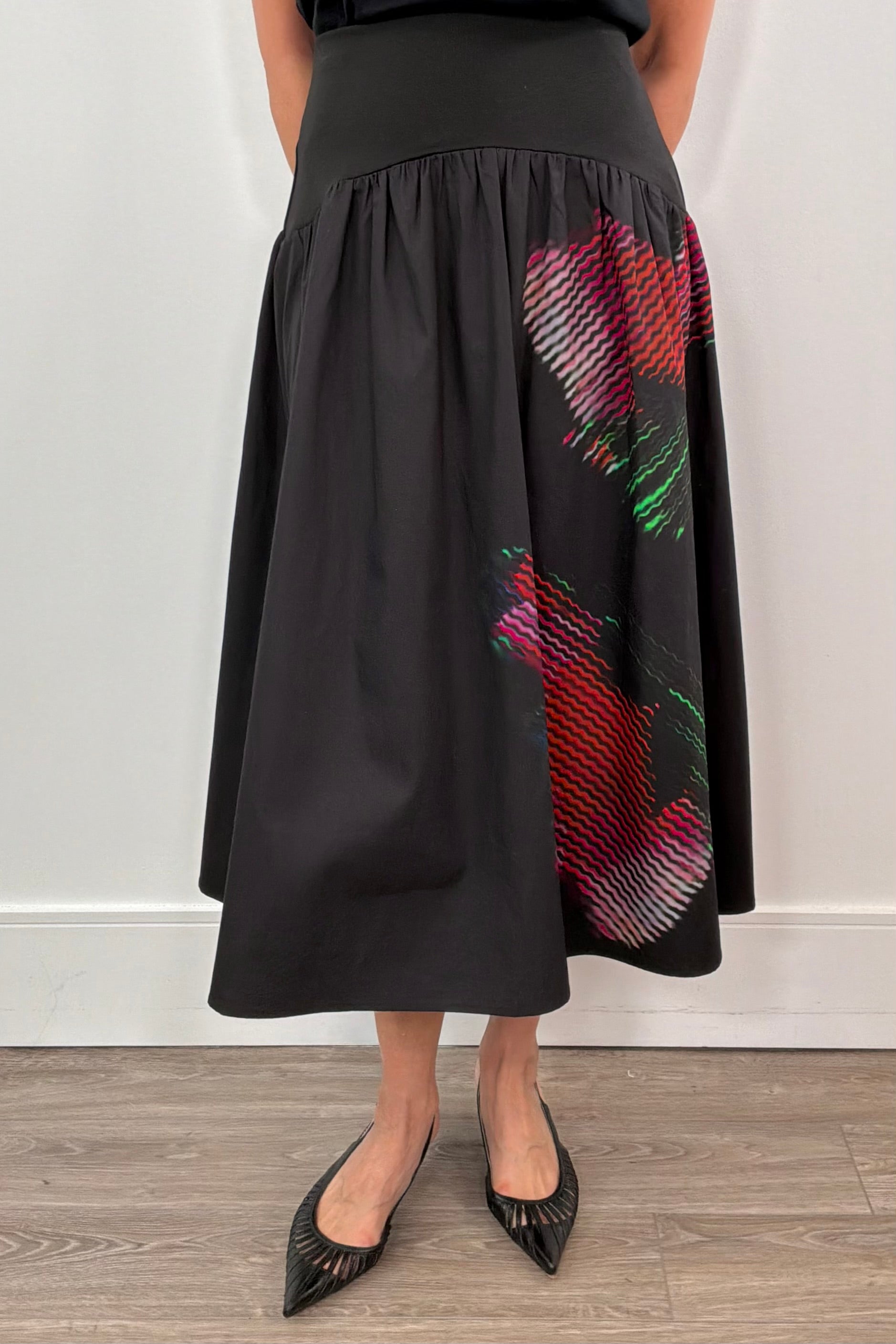 woman wearing a black poplin skirt with a floral design on the side