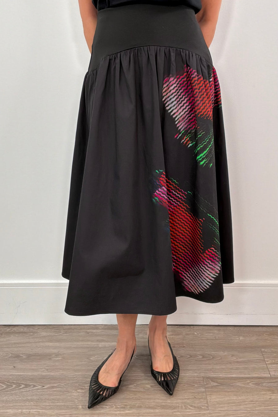 woman wearing a black poplin skirt with a floral design on the side