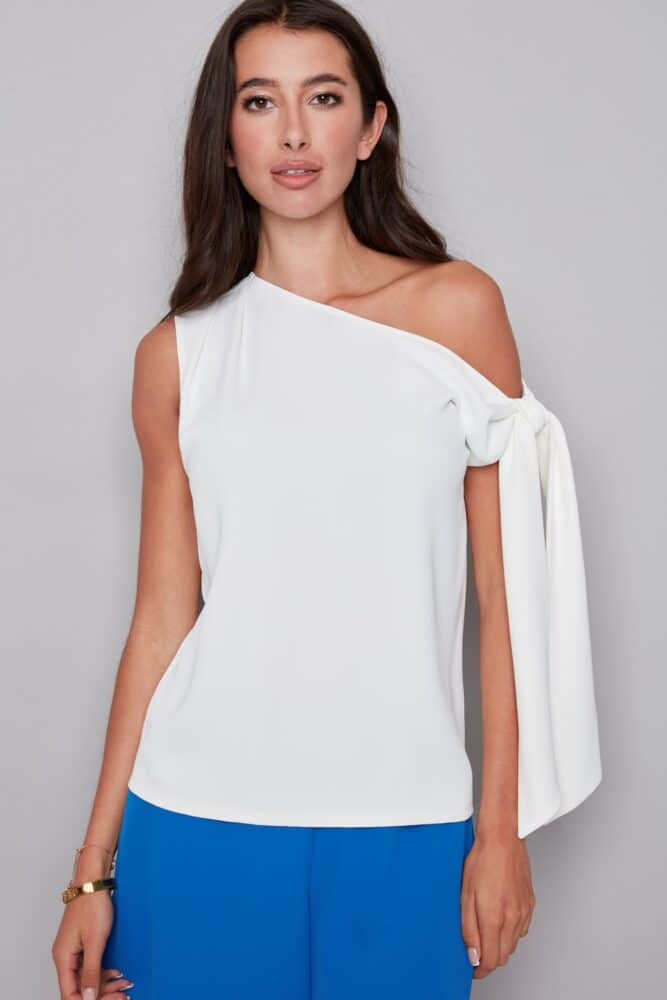 woman wearing a white one-shoulder top with a draped tie sleeve detail, front