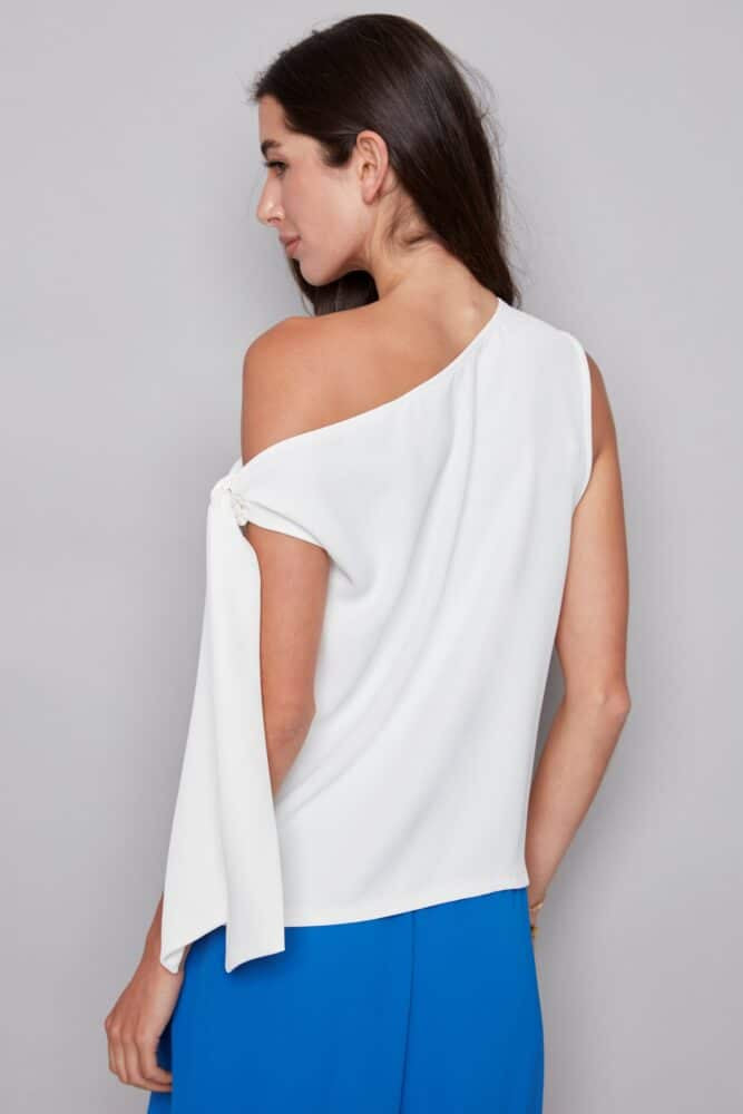 woman wearing a white one-shoulder top with a draped tie sleeve detail, back
