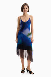 blue watercolor midi slip dress featuring a v-neckline, spaghetti straps, and a sheer mesh asymmetrical hem 