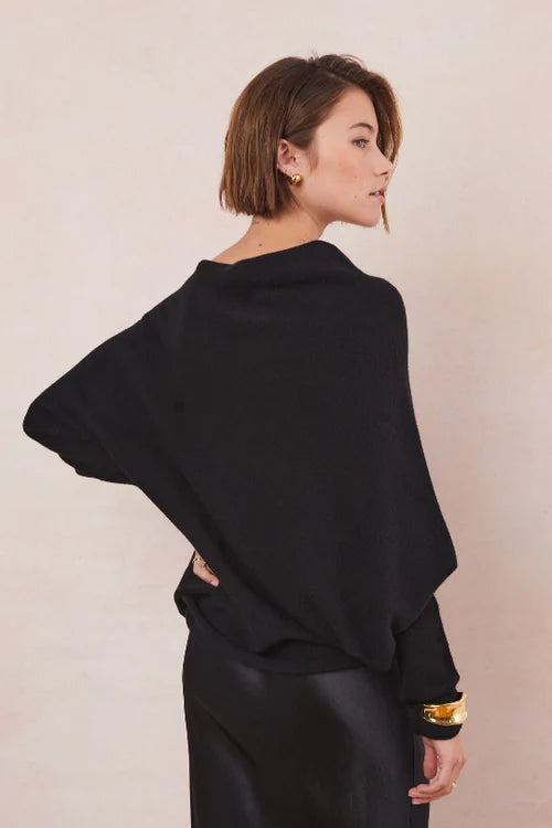 Woman wearing a black sweater and black dress 