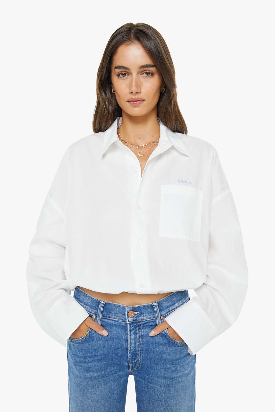 a woman wearing a cropped white button up collared shirt with a side pocket