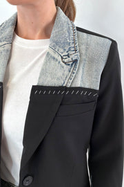 Close of Woman wearing a mixed denim fabric blazer in black and hints of light blue