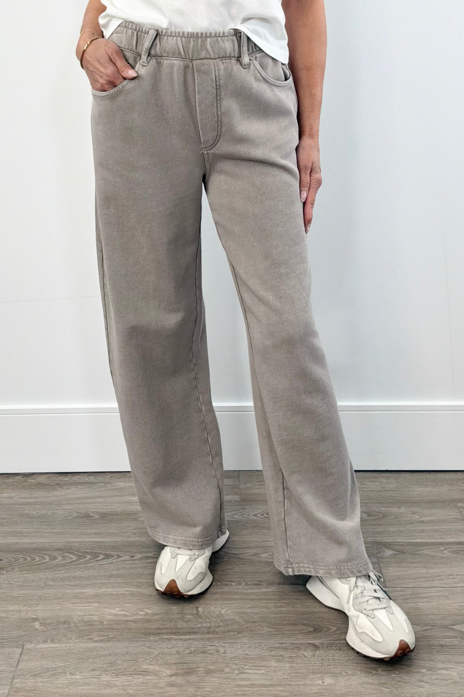 Woman wearing taupe wide leg pants with elastic waistband and front pockets