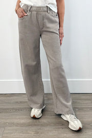 Woman wearing taupe wide leg pants with elastic waistband and front pockets