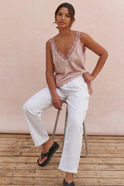 woman wearing a blush sleeveless camisole with lace trim, front