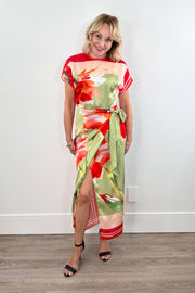 Woman wearing a boat neck short sleeve wrap waist scarf colorful floral dress 