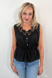 Woman wearing a sleeveless top with neckline detail in black