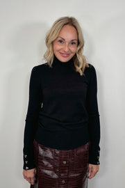 Woman wearing a black turtleneck and burgundy skirt against a white background