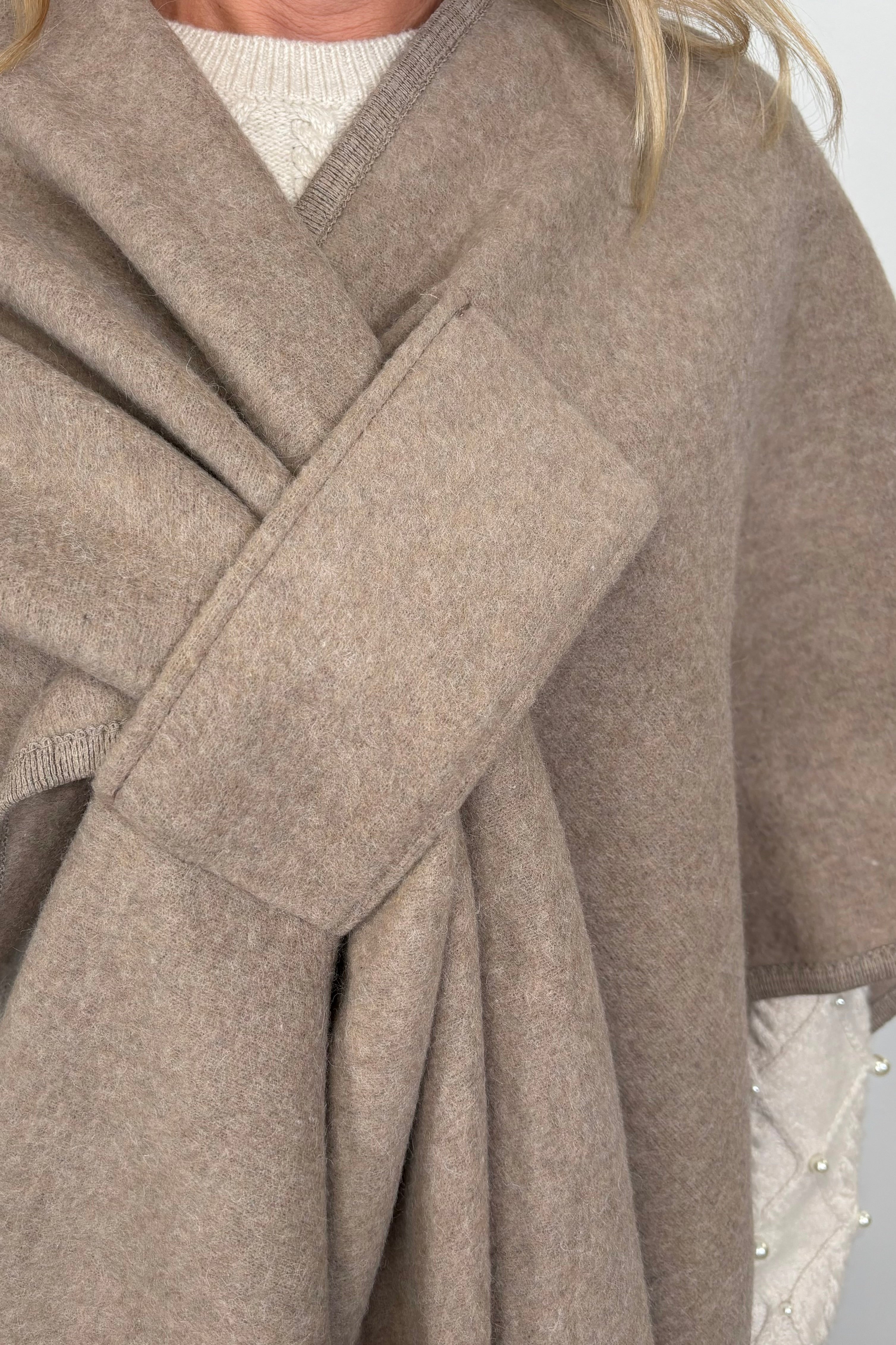 woman wearing a beige cape that looks like a bow