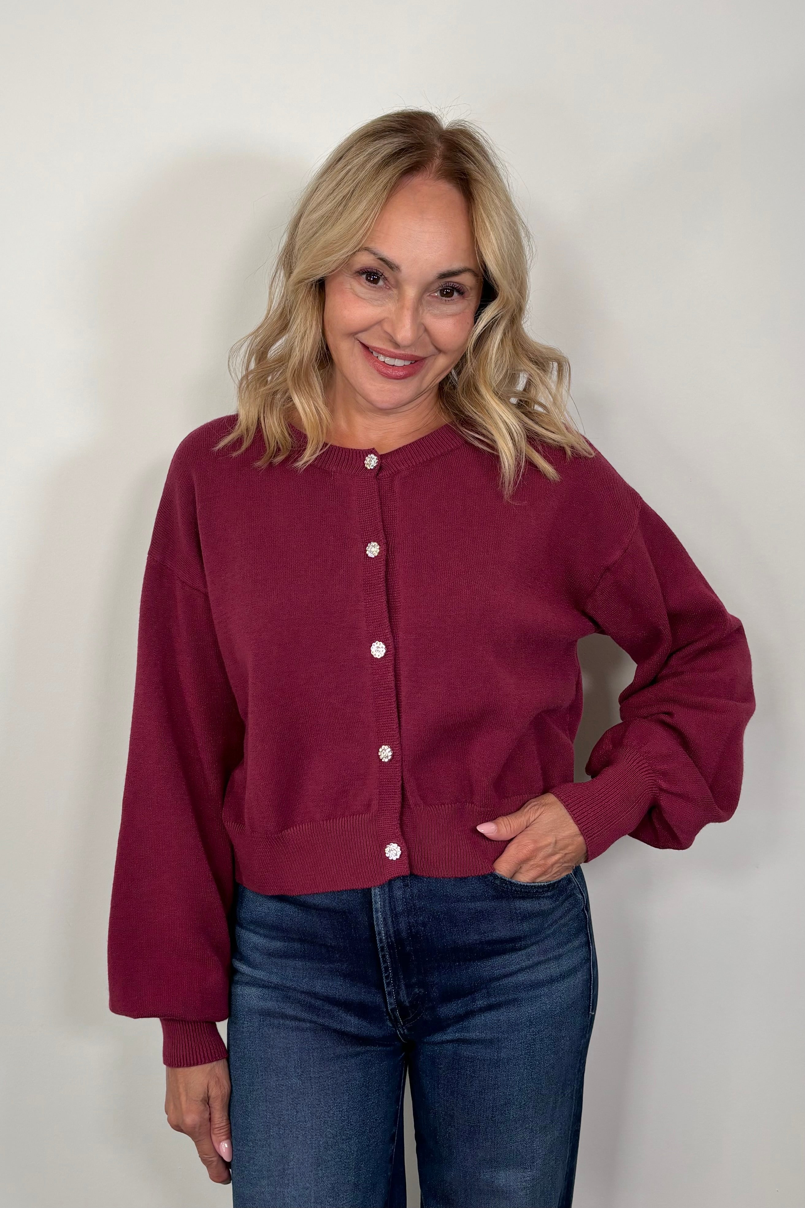 woman wearing a burgundy crystal button cardigan