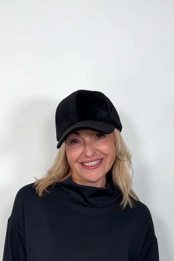 Front view of a woman wearing an black coloured baseball felt hat
