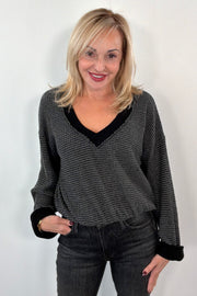 Woman wearing a black and gray top with black trim 