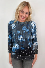 Woman wearing a blue and black floral pullover sweater 