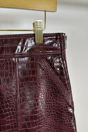 Close-up of the pocket of a short burgundy button front Russi leather skirt