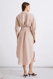 Woman wearing a blush pink collared midi dress with three-quarter sleeves, subtle embellishment, and a tie waist, back