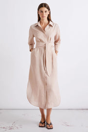 Woman wearing a blush pink collared midi dress with three-quarter sleeves, subtle embellishment, and a tie waist, front