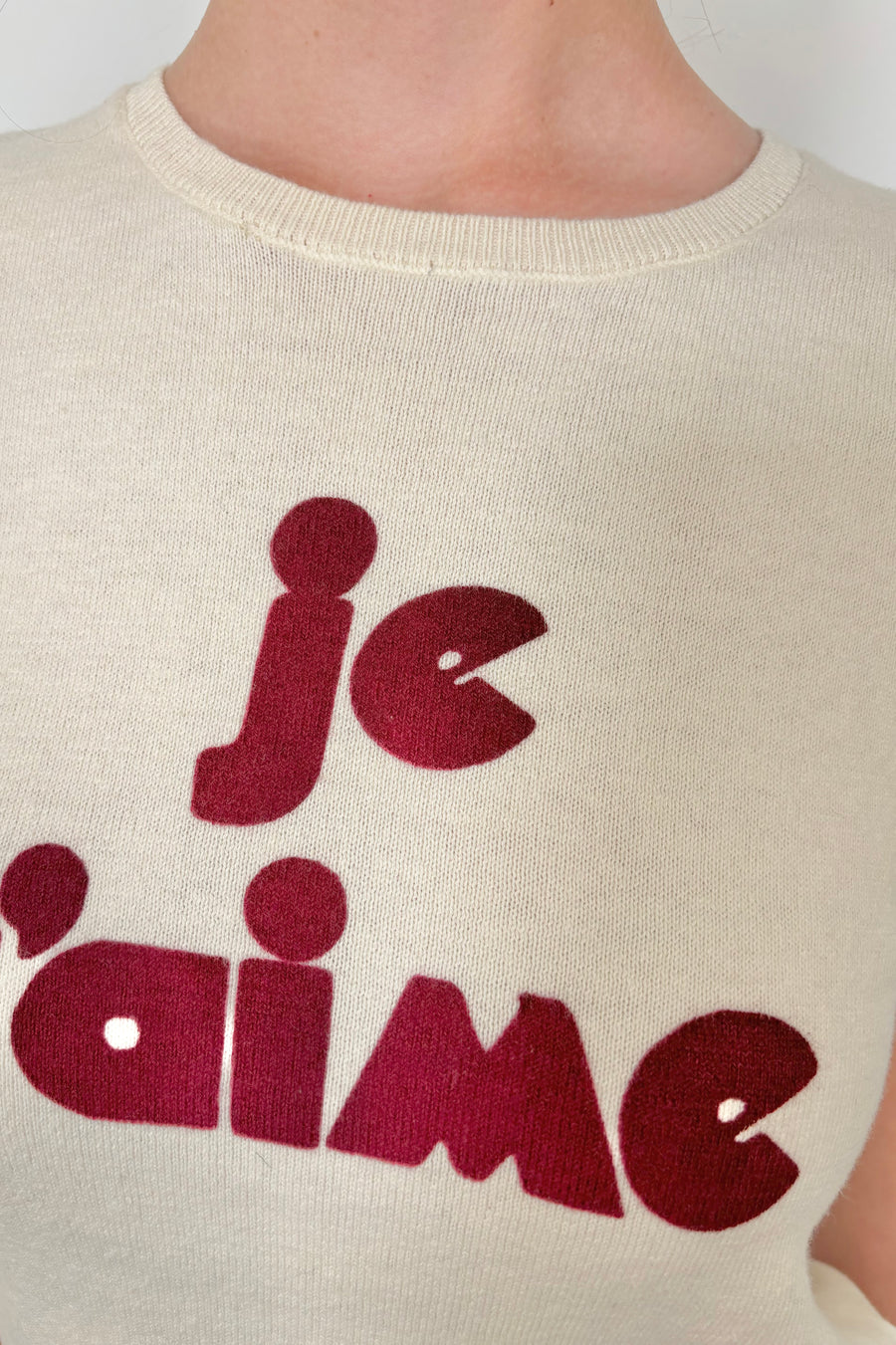 Close up view pf the text saying “Je T’Aime” on a knitted top