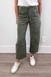 Woman wearing curved leg cargo pants with string waist in meadow green