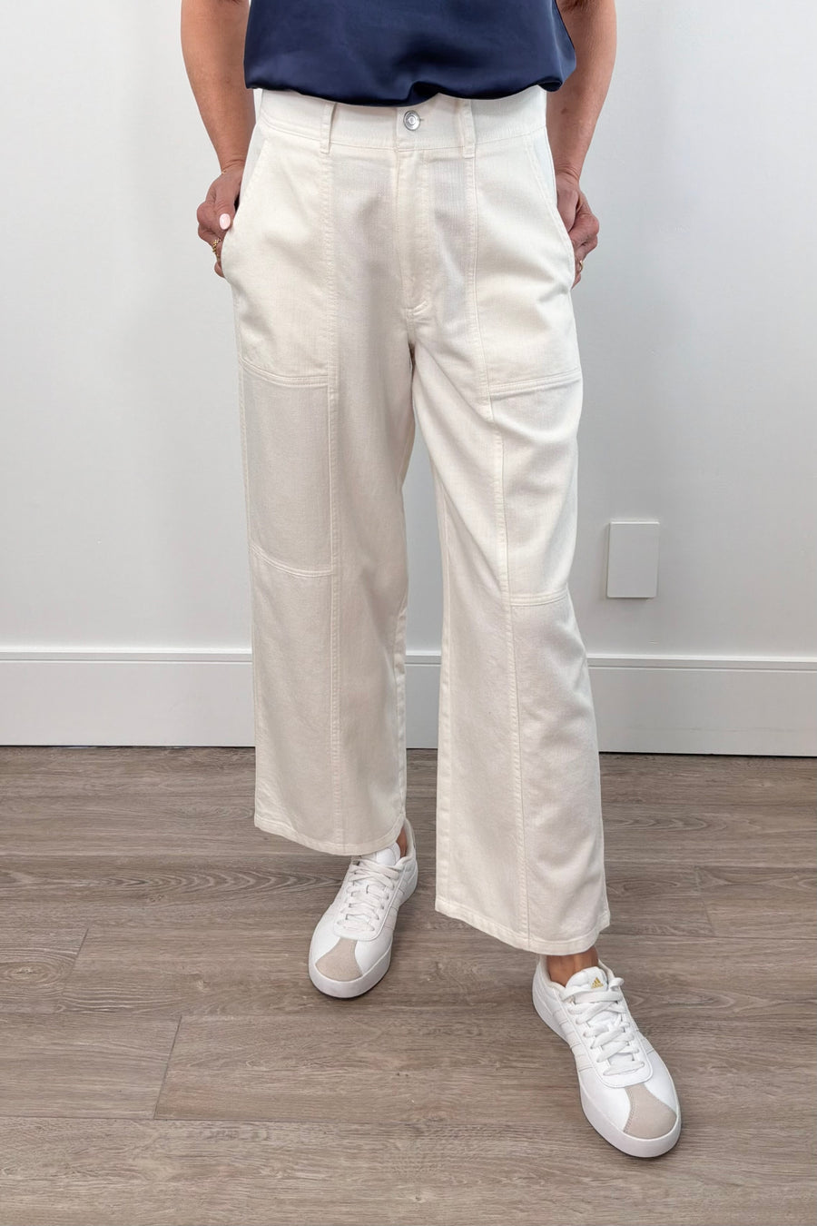 Woman wearing cream high-waisted straight-leg pants, front view