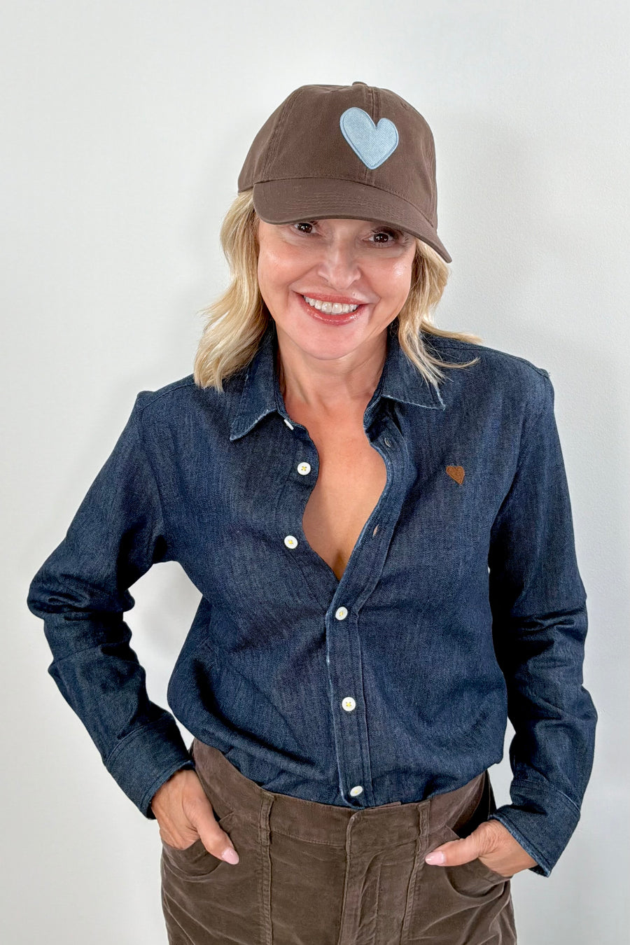 Women wearing a brown cap with a light blue heart patch