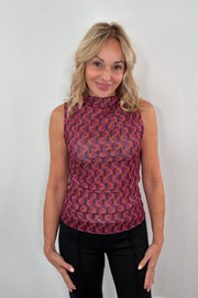 Woman wearing a sleeveless 60' patterned top 