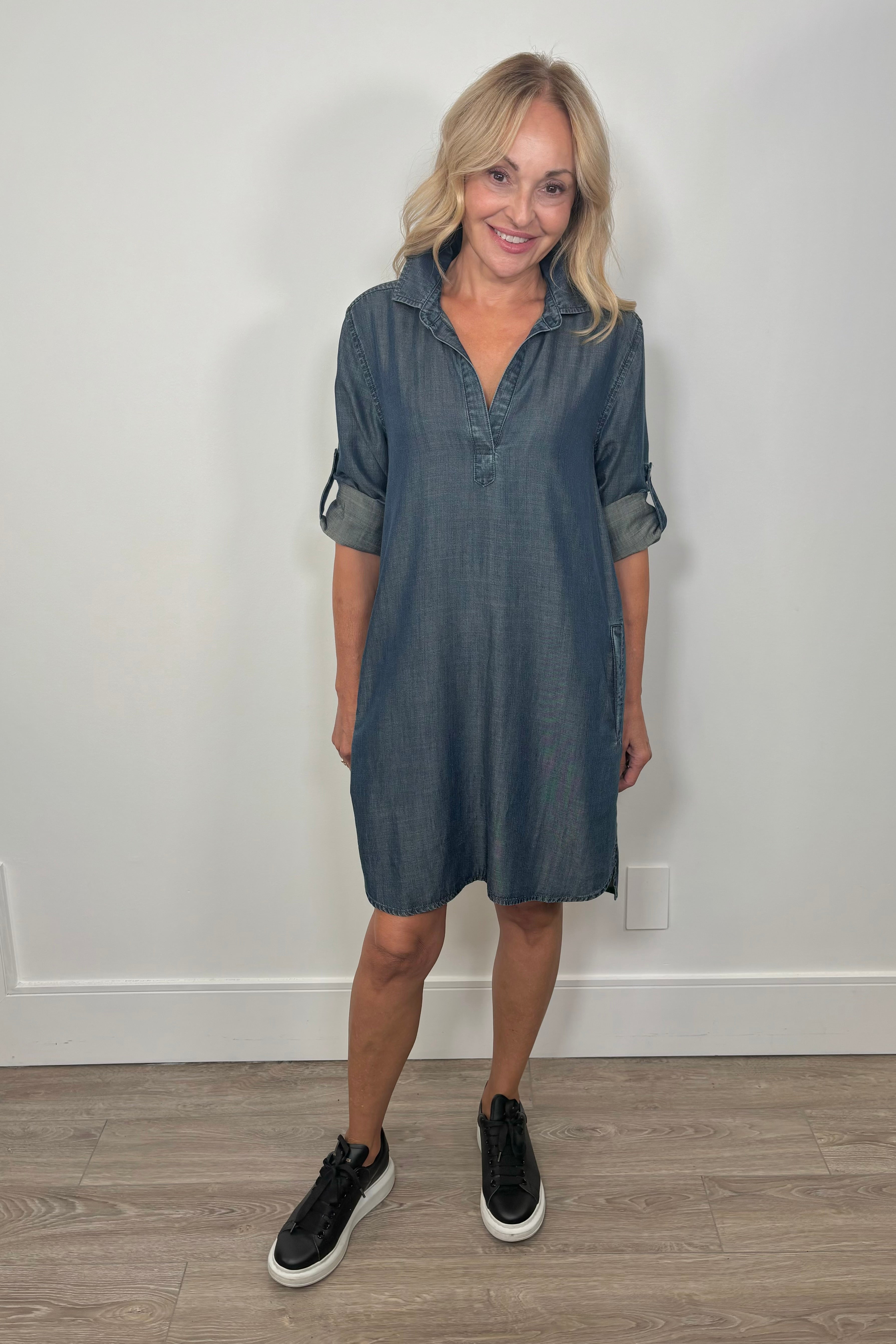 Front view of woman wearing a blue midi tencel yoke dress with cuffed sleeves 