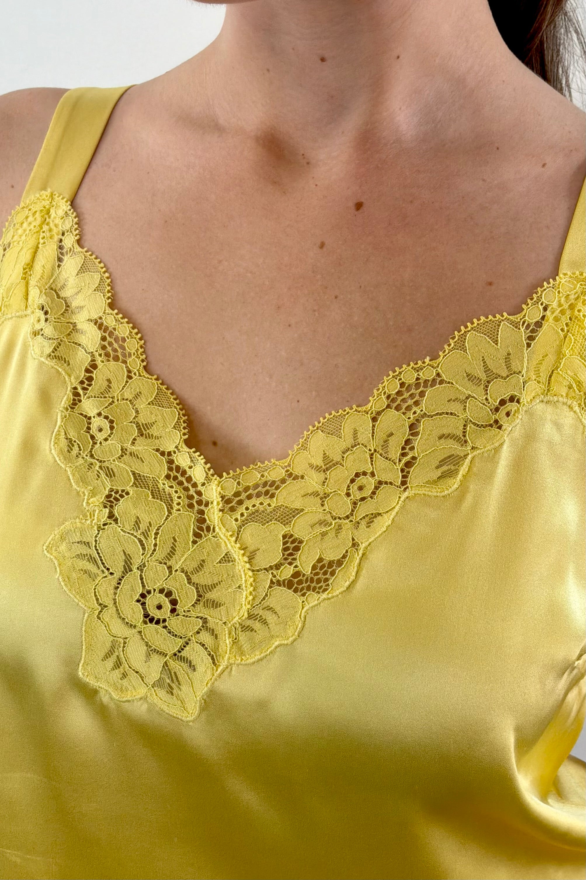 Close up of Woman wearing gold satin lace trim tank top