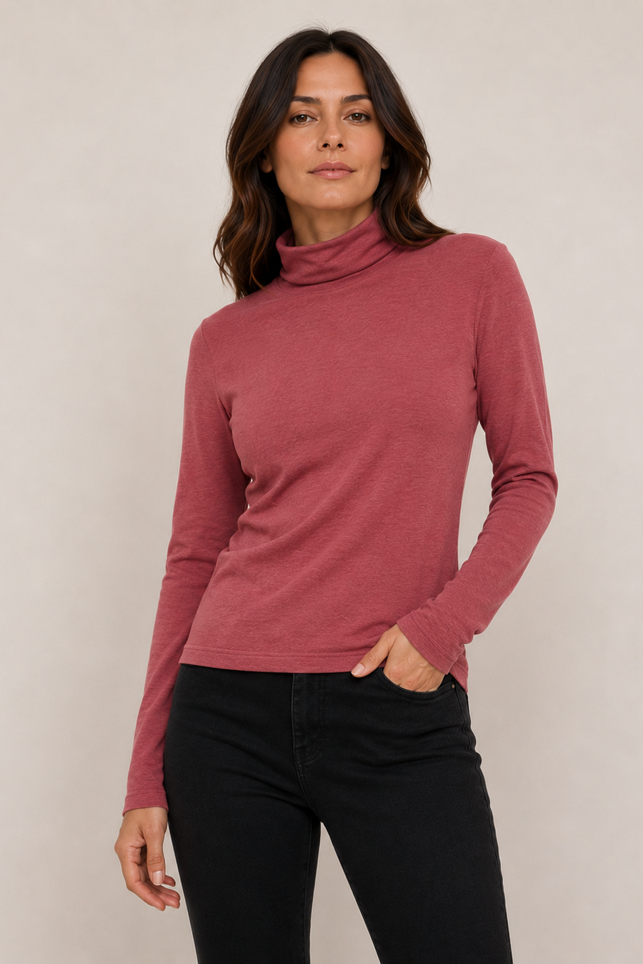 A woman wearing a dusty rose long-sleeve turtleneck sweater 