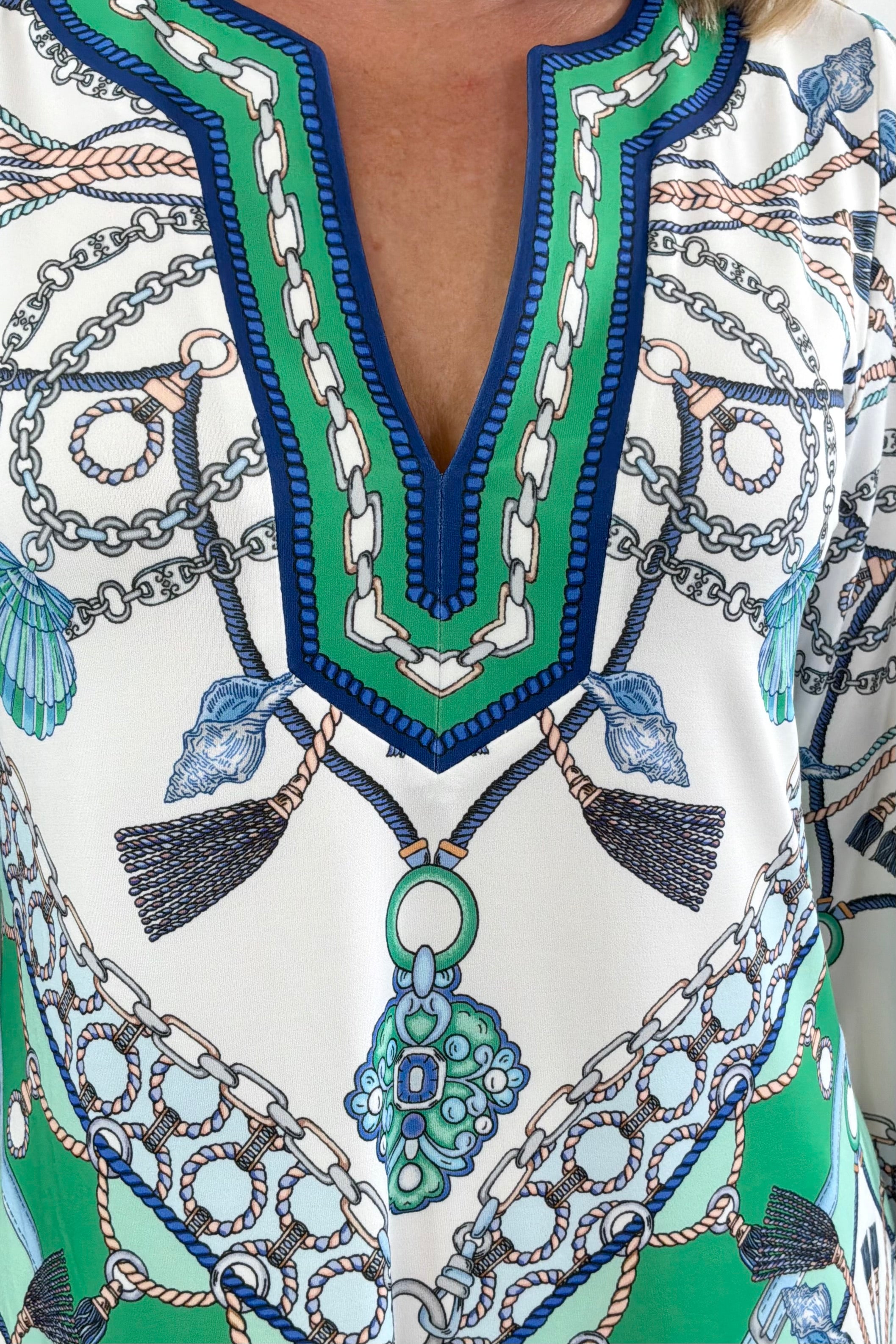 Woman wearing a white green and blue patterned dress with shell details